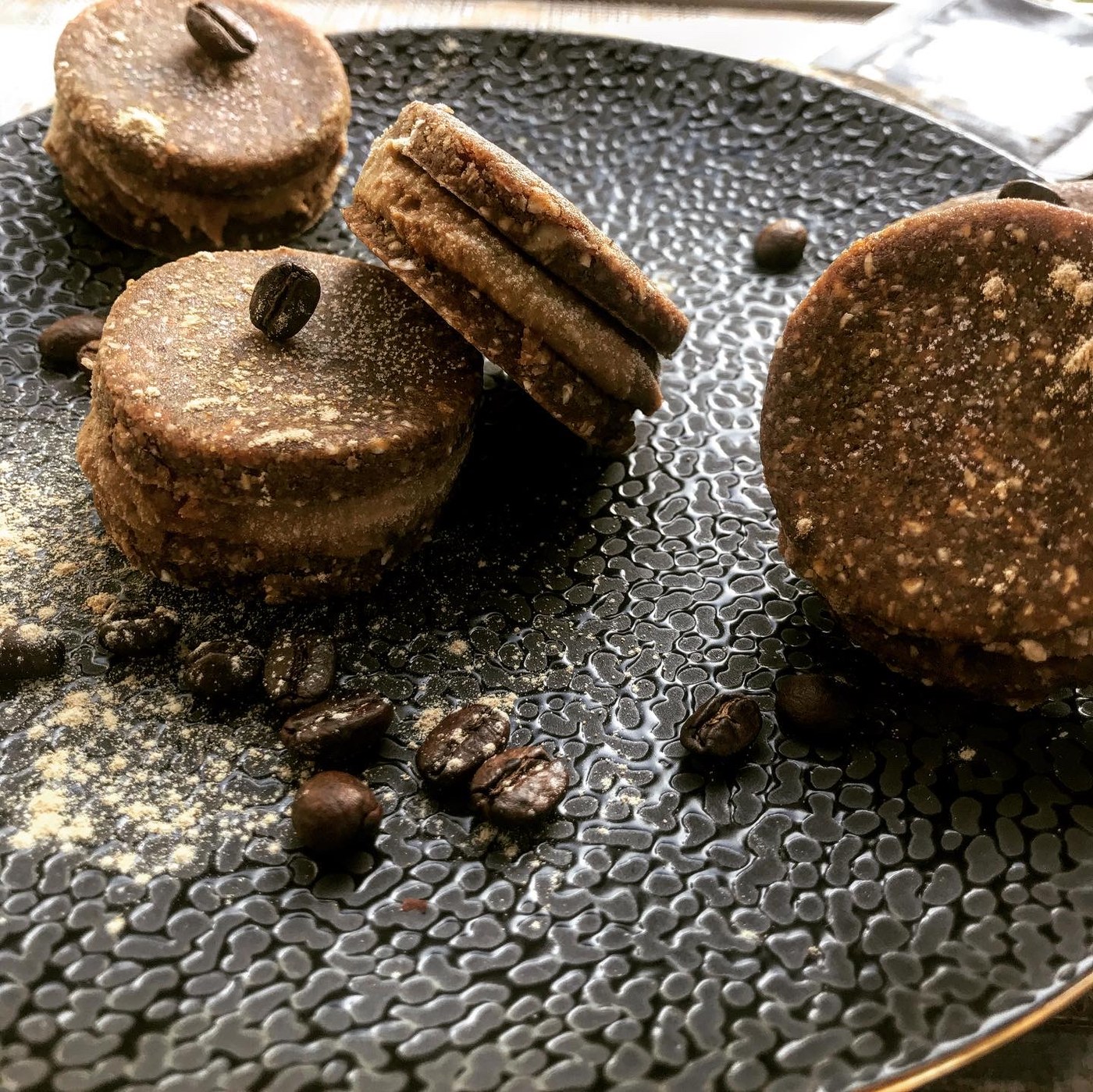 Macarons crus café cacao sur assiette noire